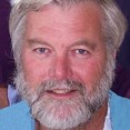A smiling man with a white beard.